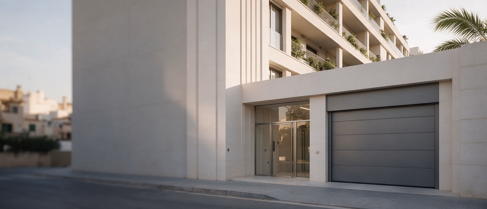 Portal de cristal y puerta seccional del garaje de un edificio de viviendas en Mallorca