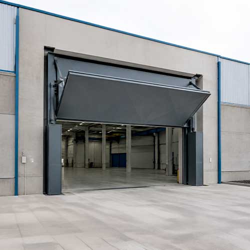 Puerta contrapesada industrial instalada en una nave