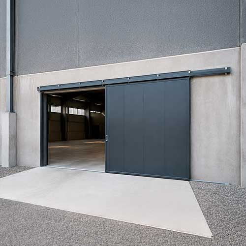 Puerta corredera industrial metálica instalada en una nave